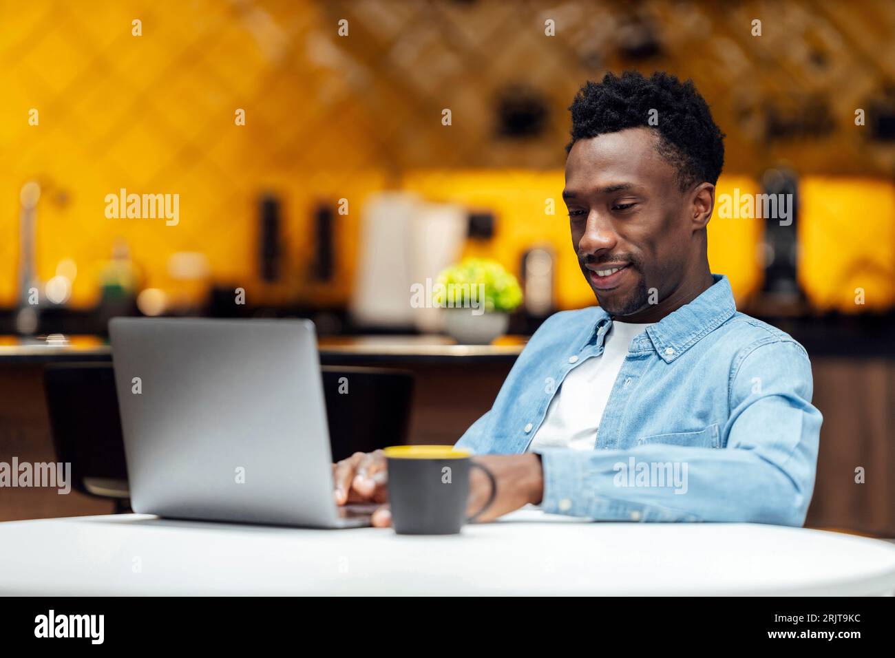 Smiling businessman using laptop at workplace Stock Photo
