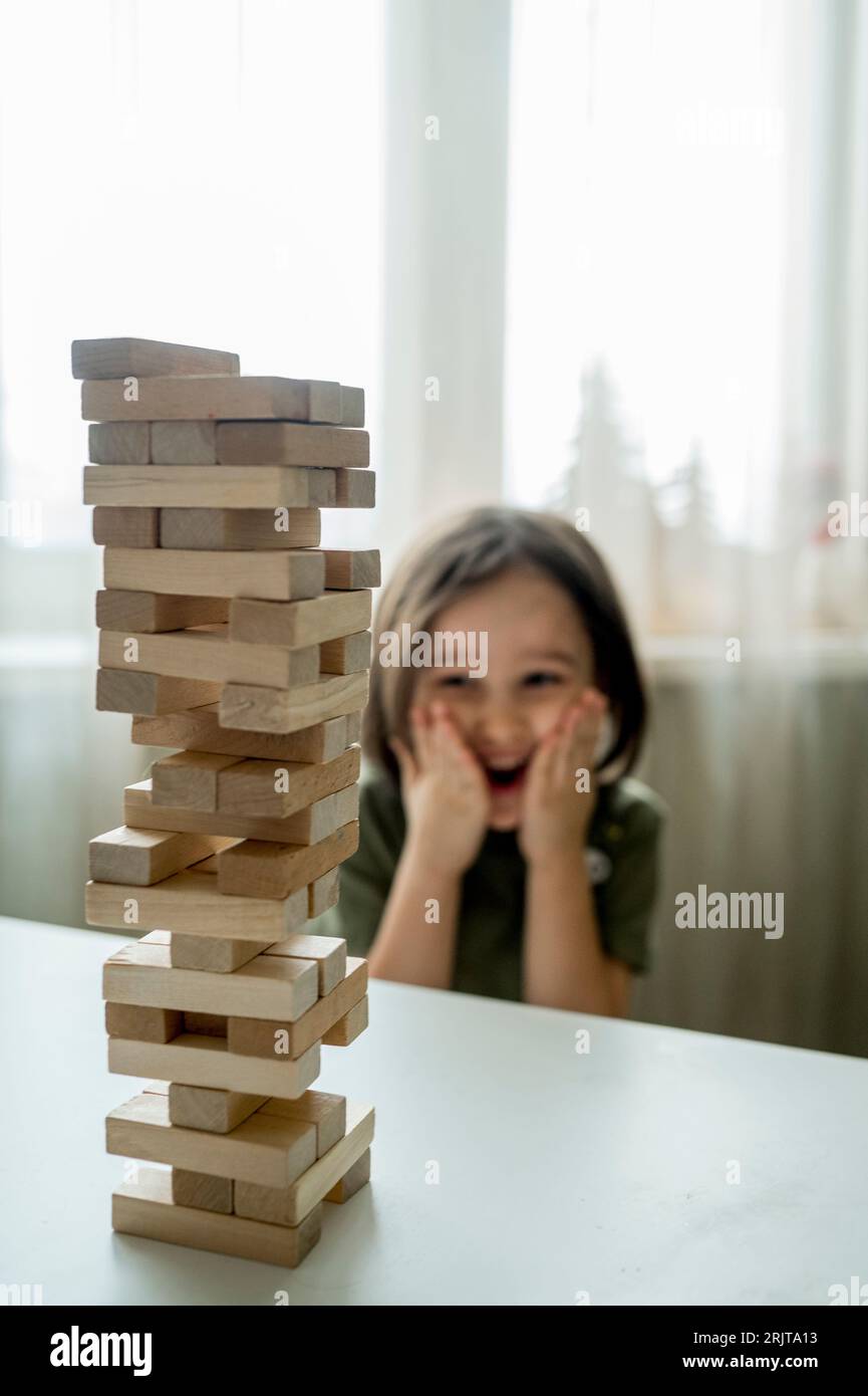 Boy looking at jenga tower on table at home Stock Photo