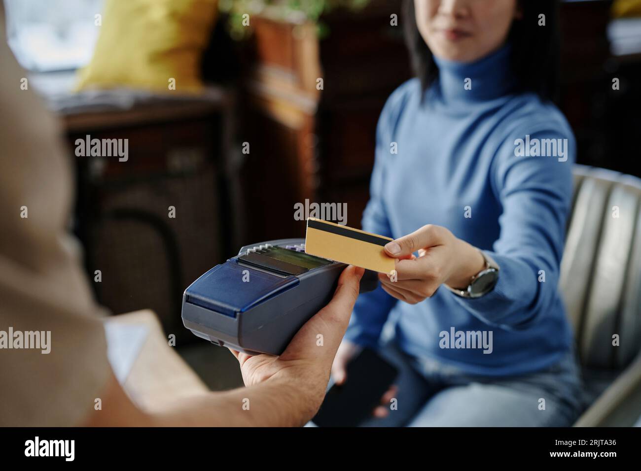 Woman paying through credit card on machine at cafe Stock Photo