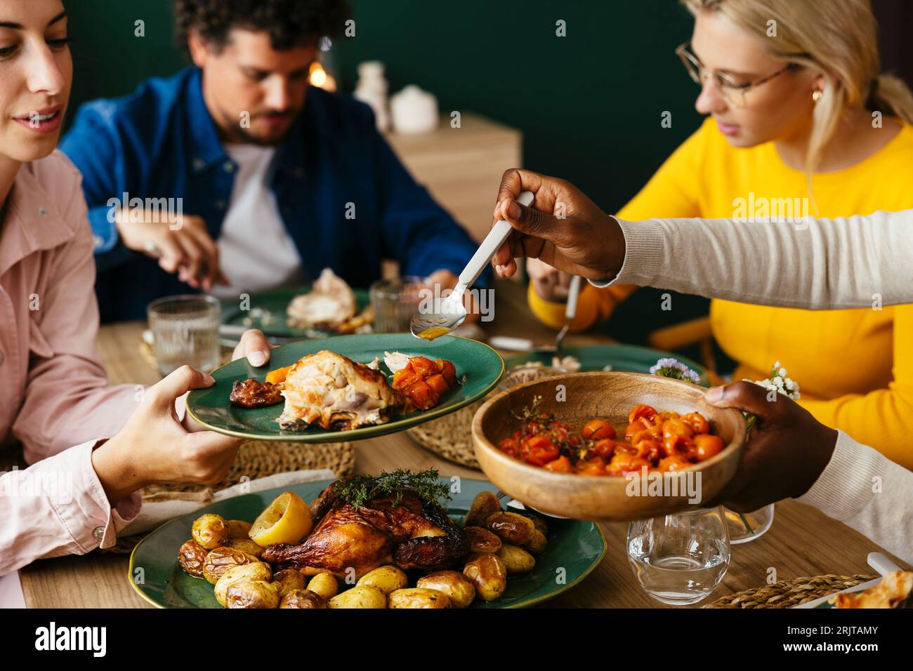 Friends sharing food at dining table Stock Photo - Alamy