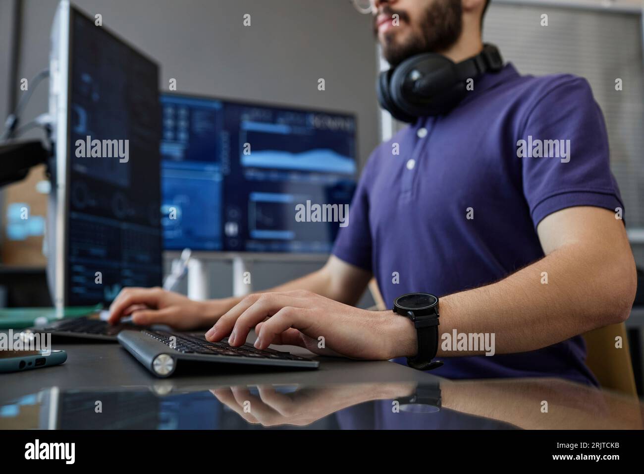 IT professional typing on computer keyboard at desk Stock Photo