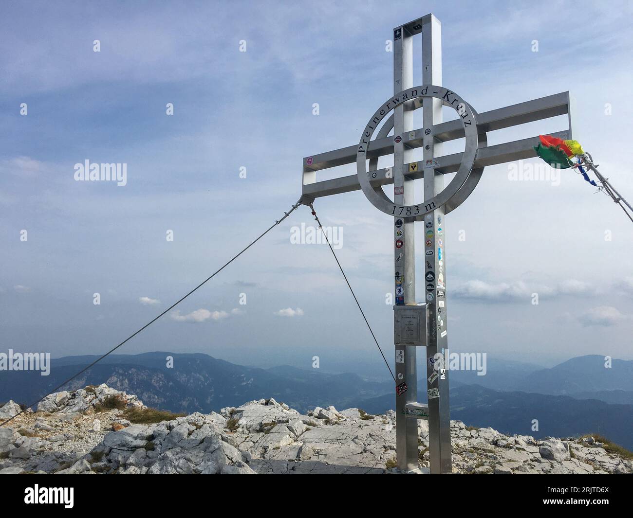 A cross with an arrow symbol on it stands atop a rocky outcropping: Austria, Rax, Preiner Kreuz Stock Photo