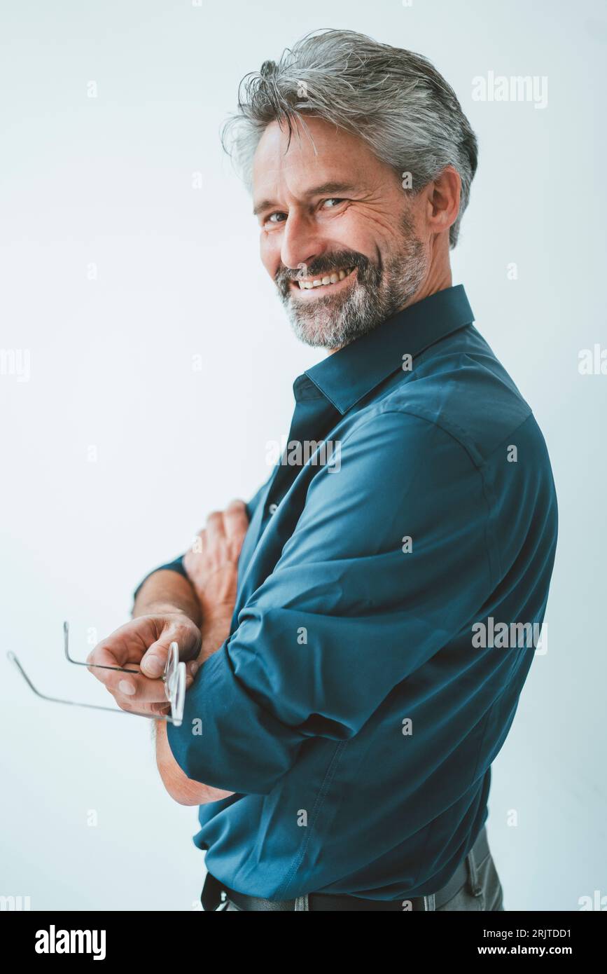 Happy businessman standing with arms crossed Stock Photo - Alamy