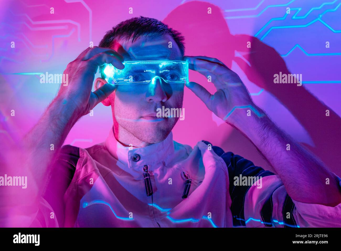 Man wearing smart glasses in neon lights Stock Photo