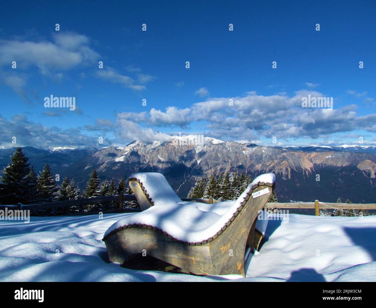 View of mountain Dobratsch, Dobrac in Carinthia or Karnten in Austria Osterreich in Gailtal Alps with two snow covered sunbathing chairs in front Stock Photo