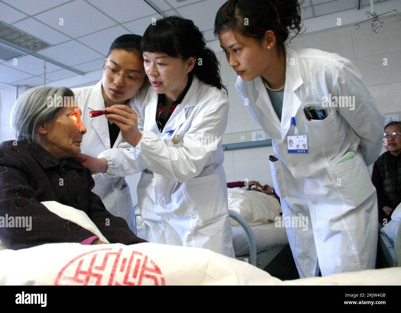 Bildnummer: 51844613  Datum: 24.04.2007  Copyright: imago/Xinhua Junge Ärzte untersuchen die Augen einer alten Frau die am Grauen Star erkrankt ist im Ningxia Medical College in Yinchuan in der Region Ningxia Hui PUBLICATIONxNOTxINxCHN, Personen; 2007, Yinchuan, Arzt, Ärzte, Krankheit, krank, kranke, Kranker, Frau, alt, alte, Rentner, Senioren, Seniorin, Krankenhaus, Krankenhäuser, Klinik, Kliniken, untersuchen, Untersuchung, Behandlung, medizinische, medizinisch, jung, junge, Grauer Star, Graue, Einheimische, Einheimischer, Chinese, Chinesin, Chinesen, Augenkrankheit, Augenkrankheiten; , quer Stock Photo
