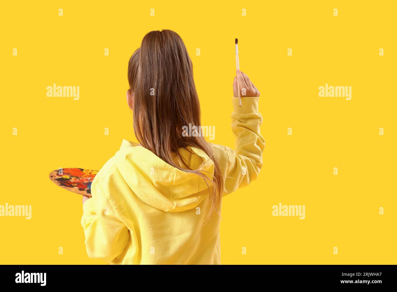 Cute little girl with paint palette and brush on yellow background ...