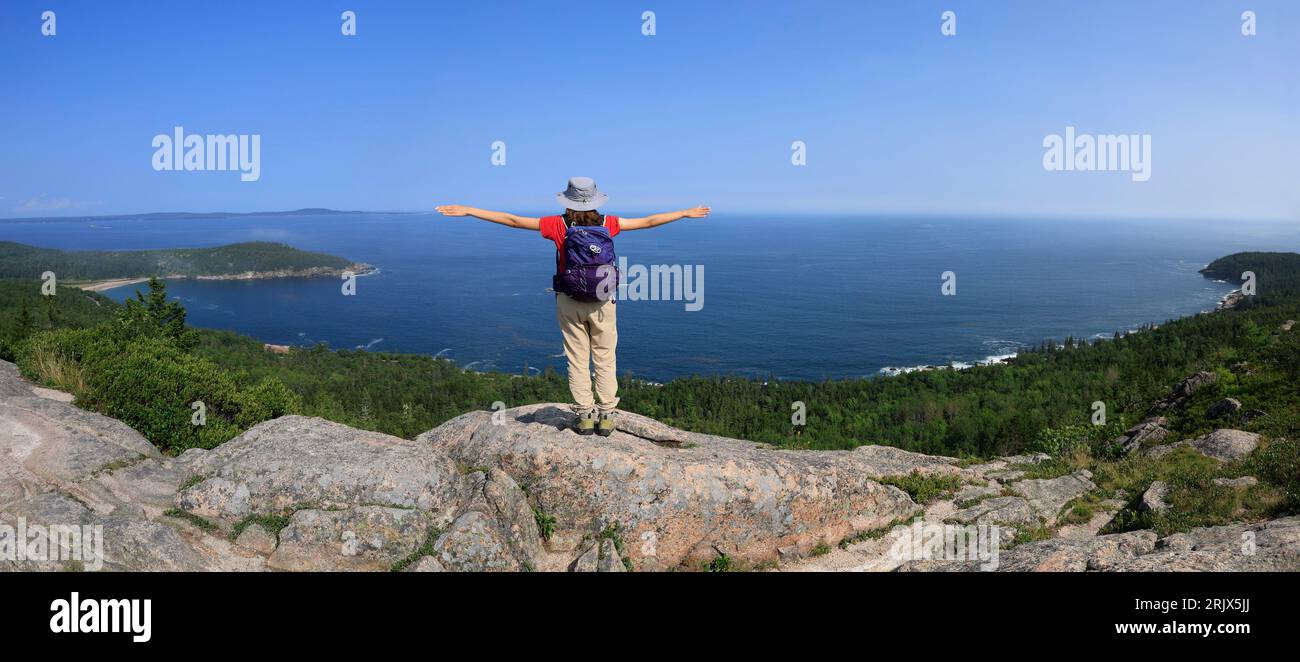 Young hiker standing on the rock and enjoying the landscape in Acadia National Park, Maine, USA Stock Photo