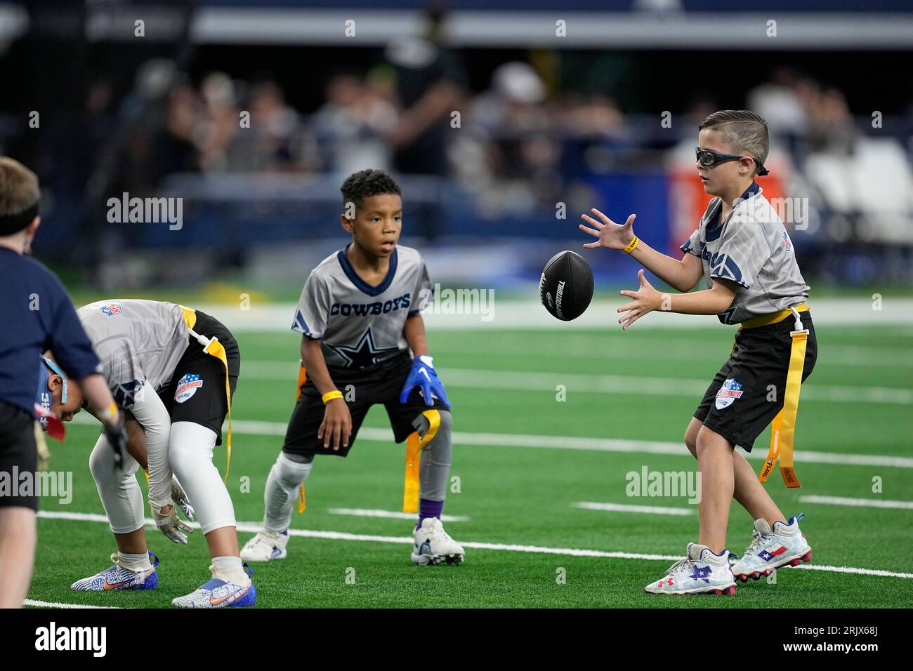 Young athletes play a quick game of flag football during halftime of a  presesaon NFL football game between the Jacksonville Jaguars and Dallas  Cowboys in Arlington, Texas, Saturday, Aug. 12, 2022. (AP