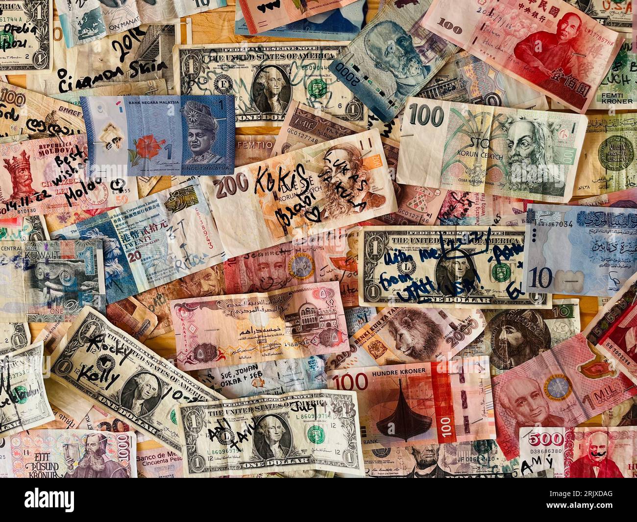 Collection of paper currency from around the world pinned to a bulletin board. Stock Photo