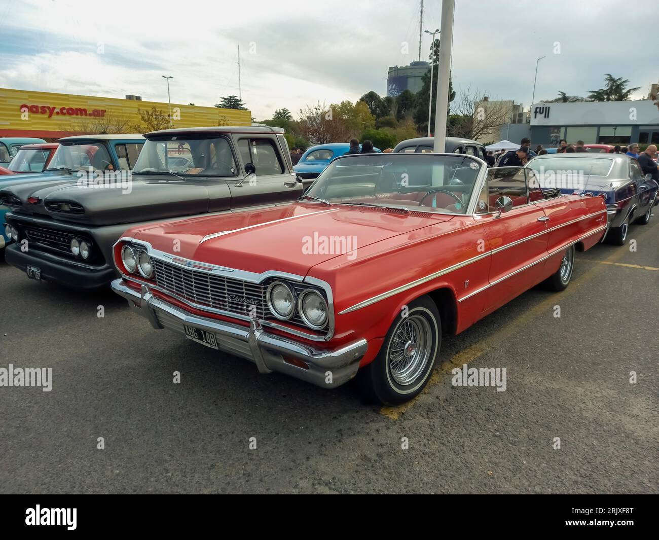 Old red 1964 Chevrolet Chevy Impala SS Super Sport V8 two-door convertible by GM in a parking lot. Stock Photo