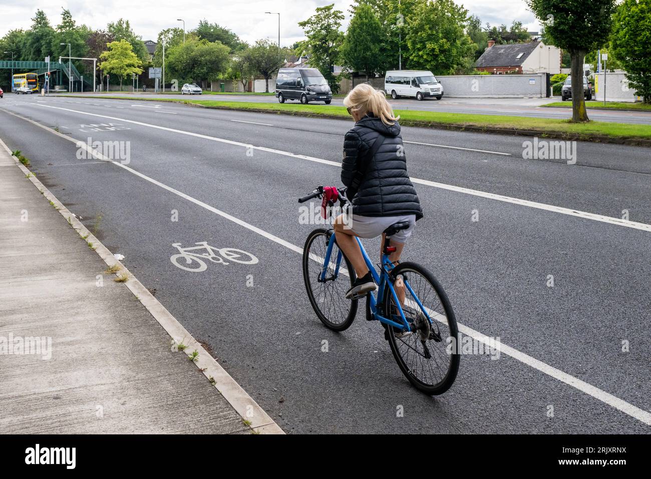 Woman riding a bicycle in a cycle lane in Dublin, Ireland. Stock Photo