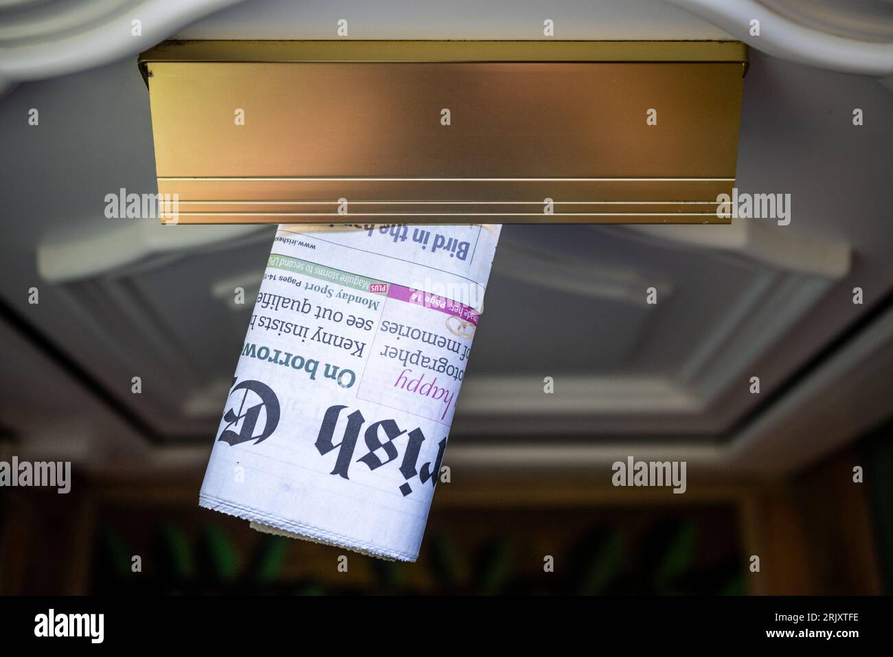 Irish Examiner broadsheet newspaper delivered though a domestic letterbox in Ireland. Stock Photo