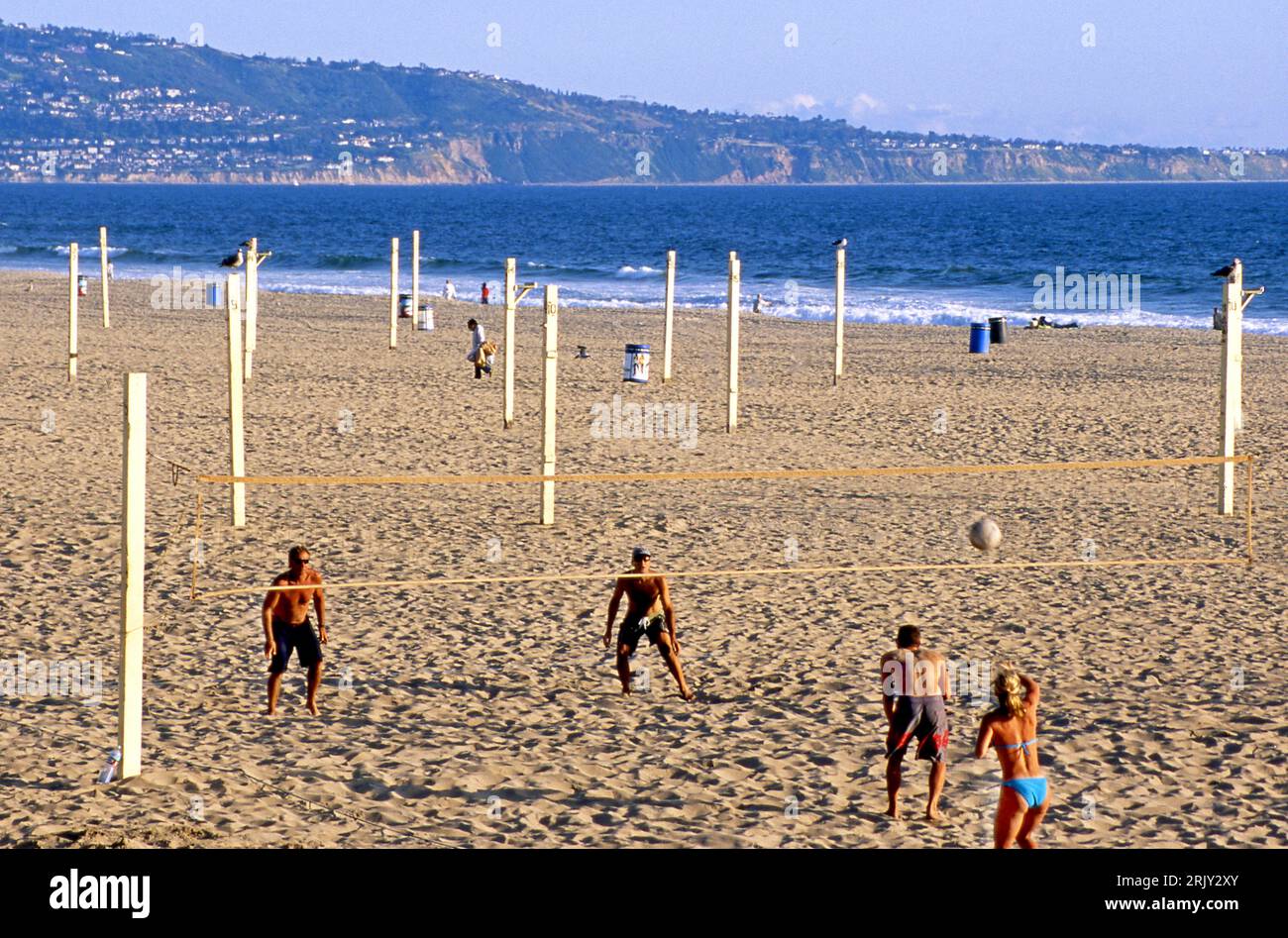 Beach volleyball game at Manhattan Beach with Palos Verdes peninsula in