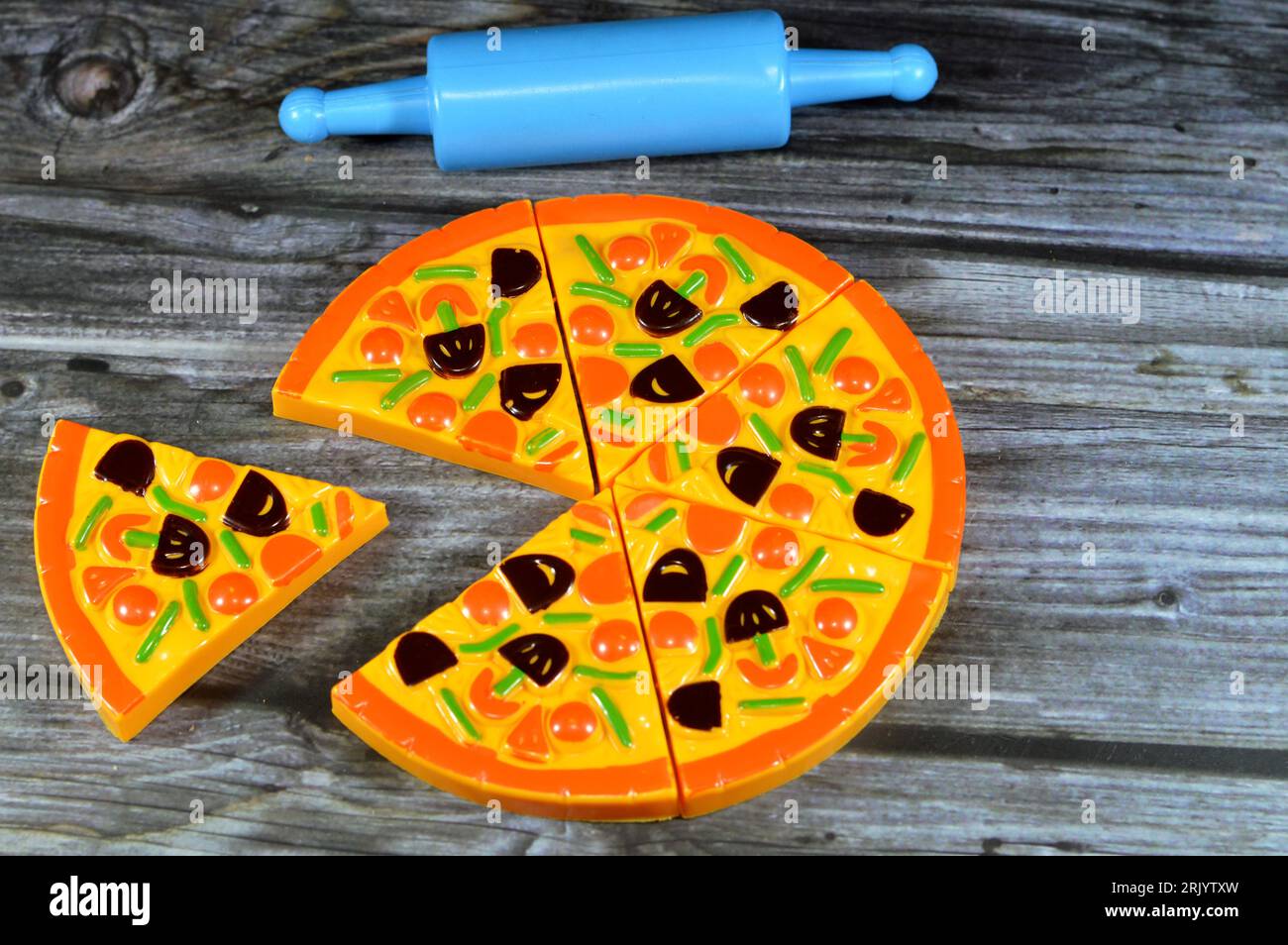 set of pizza toy for kids, slices of unreal pizza for playing games for children isolated on wooden background, gaming concept for kids, selective foc Stock Photo