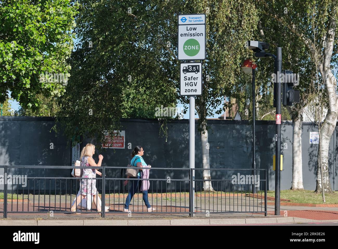 London, UK. Pedestrians walk past a Low Emission Zone sign in south-west London. Stock Photo
