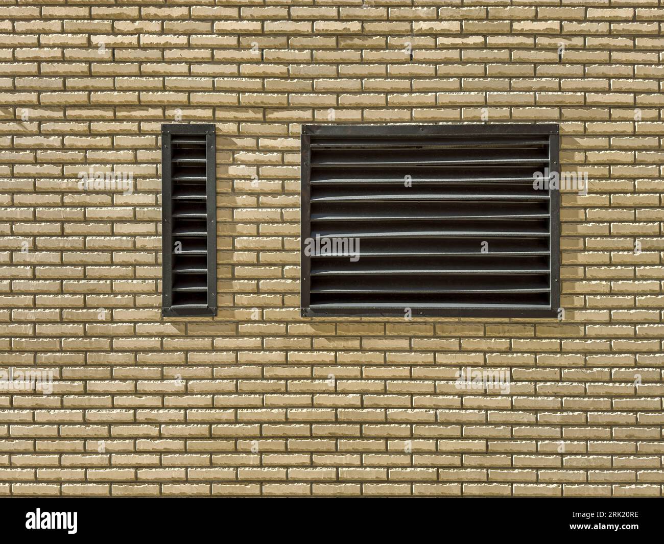 metal lattice of technical ventilation window on brick wall of renovated industrial building. Stock Photo