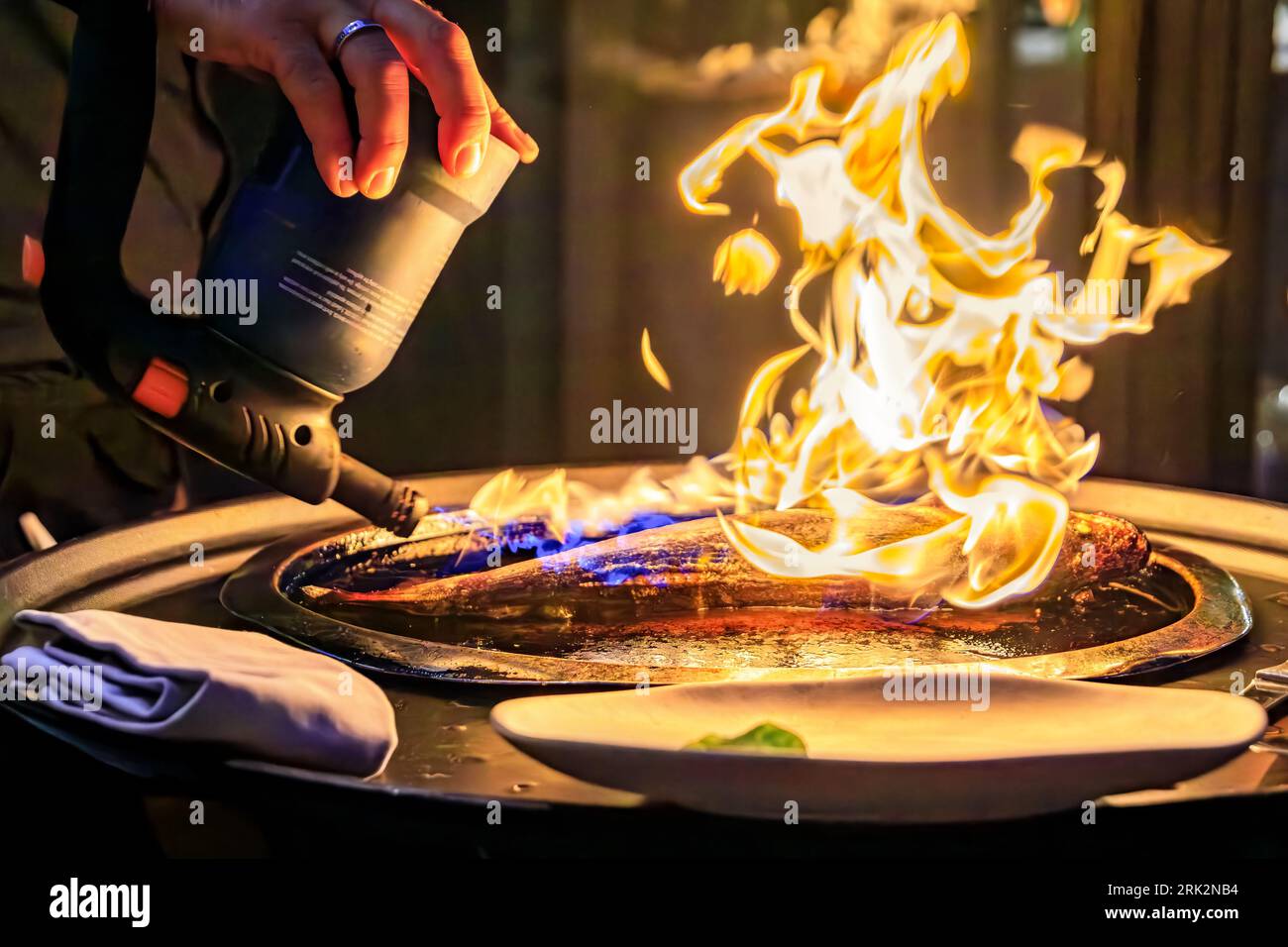 Branzino or Mediterranean sea bass seared with a torch fire at the