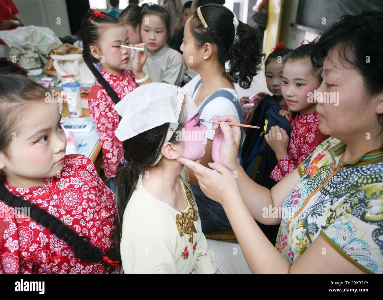 Bildnummer: 53314540  Datum: 02.09.2009  Copyright: imago/Xinhua (090902) -- TAIZHOU (JIANGSU), Sep. 2, 2009 (Xinhua) -- Teachers make face-paintings for pupils prior to their performance of Beijing Opera at Dapu primary school in Taizhou City in east China s Jiangsu Province, Sept. 2, 2009. Schools in China have introduced the learning of traditional Beijing Opera to students for their early understanding of the national treasure of arts. (Xinhua/Gu Jun) (xxh) (6)CHINA-JIANGSU-SCHOOL LEARNING-BEIJING OPERA (CN) PUBLICATIONxNOTxINxCHN China Schule Bildung Kinder Pekingoper Peking Oper Theater Stock Photo