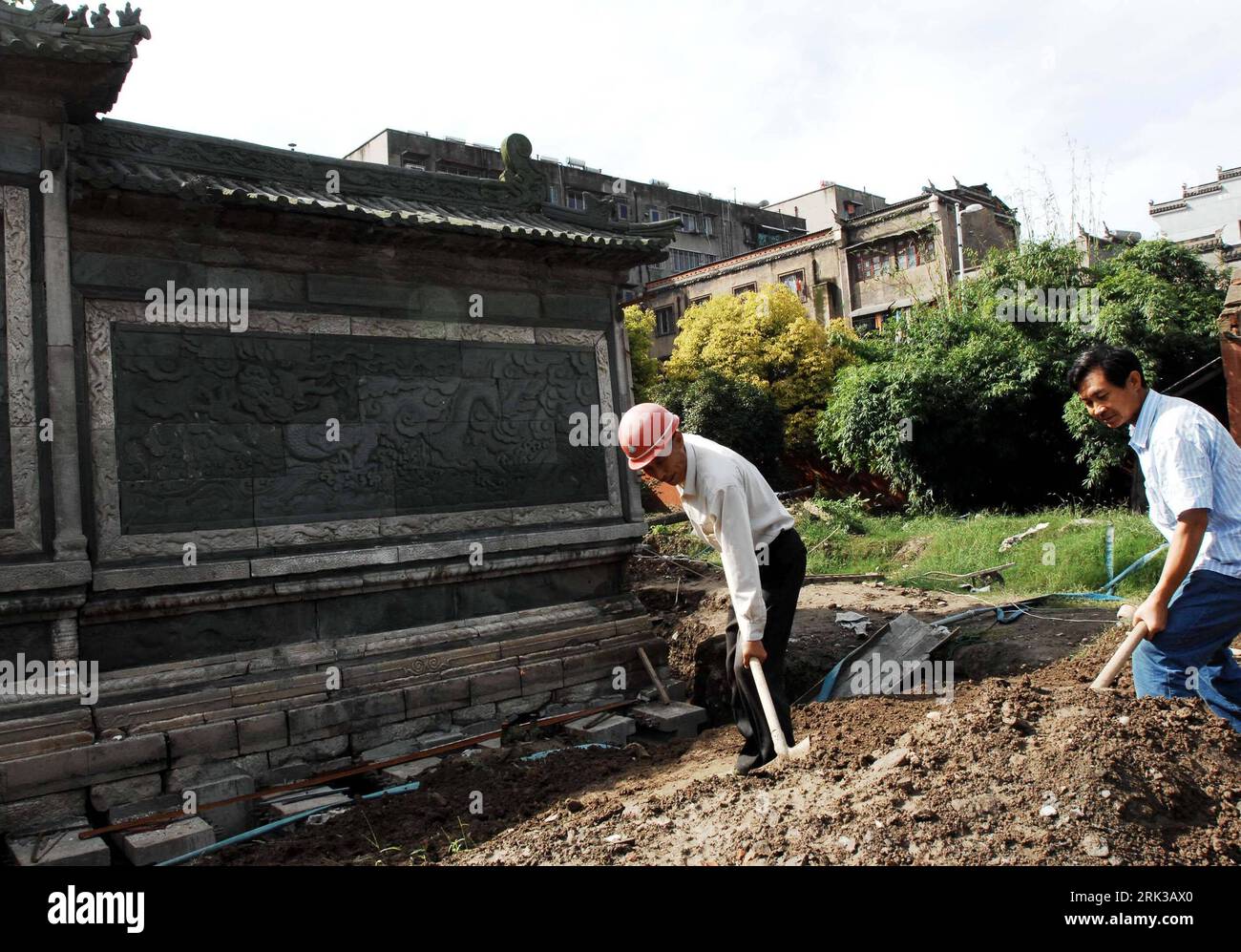 Bildnummer: 53401070  Datum: 21.09.2009  Copyright: imago/Xinhua  -- XIANGFAN,  (Xinhua) -- Two workers backfill the soil to tamp up the basement of the Green Screen Wall, a key cultural relics unit under the State s protection, after the completion of its renovation project for supporting upward straight and elevation from the sunken ground, in Xiangfan, central China s Hubei Province, Sept. 21, 2009. The Green Screen Wall, the only remnant of what used to be Xiangyang King s Mansion during the Ming Dynasty (1368-1644), and one of local best known tourist attractions, has been leaning backwar Stock Photo