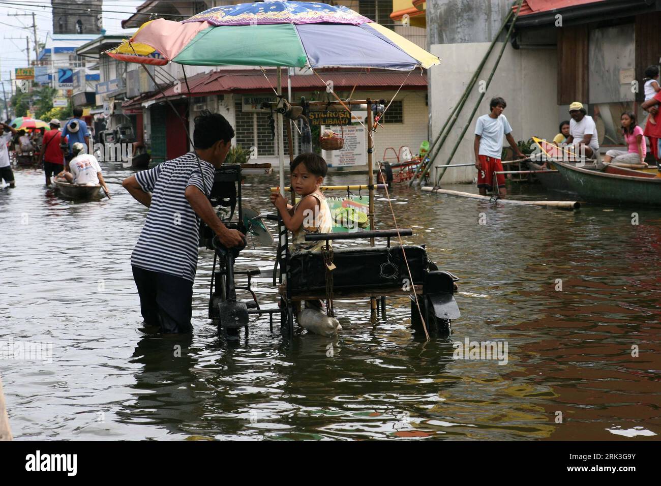Bildnummer: 53506500  Datum: 05.10.2009  Copyright: imago/Xinhua (091005) -- MANILA, Oct. 5, 2009 (Xinhua) -- Filipinos walk in floodwaters in Santa Cruz town, south of Manila, capital of the Philippines, on Oct. 5, 2009. At least 16were killed, mostly buried in landslides, as Typhoon Parma swept through the Philippines northern coast since Oct. 3, leaving trees uprooted, power pylons toppled and houses damaged. (Xinhua/Sybhel Cordero) (lr) (6)THE PHILIPPINES-TYPHOON PARMA-AFTERMATH PUBLICATIONxNOTxINxCHN Philippinen Taifun Parma Naturtatastophen Flut Überschwemmung kbdig xub 2009 quer premium Stock Photo