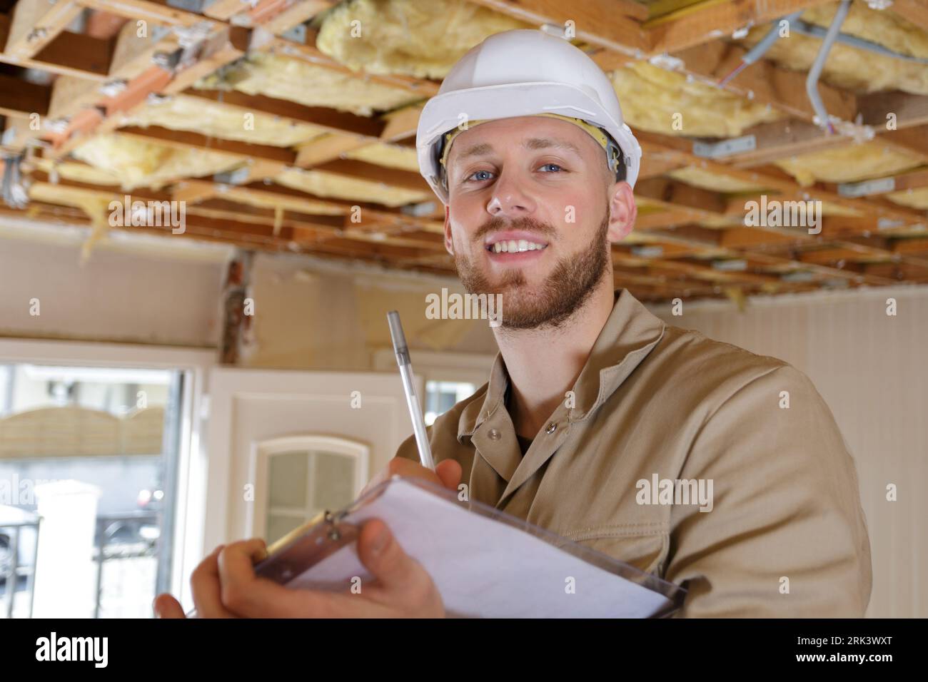 happy builder thinking about something indoors Stock Photo