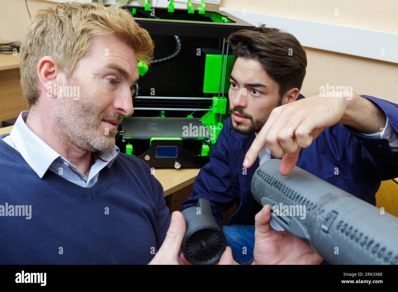 engineers in discussion while looking at model aircraft Stock Photo