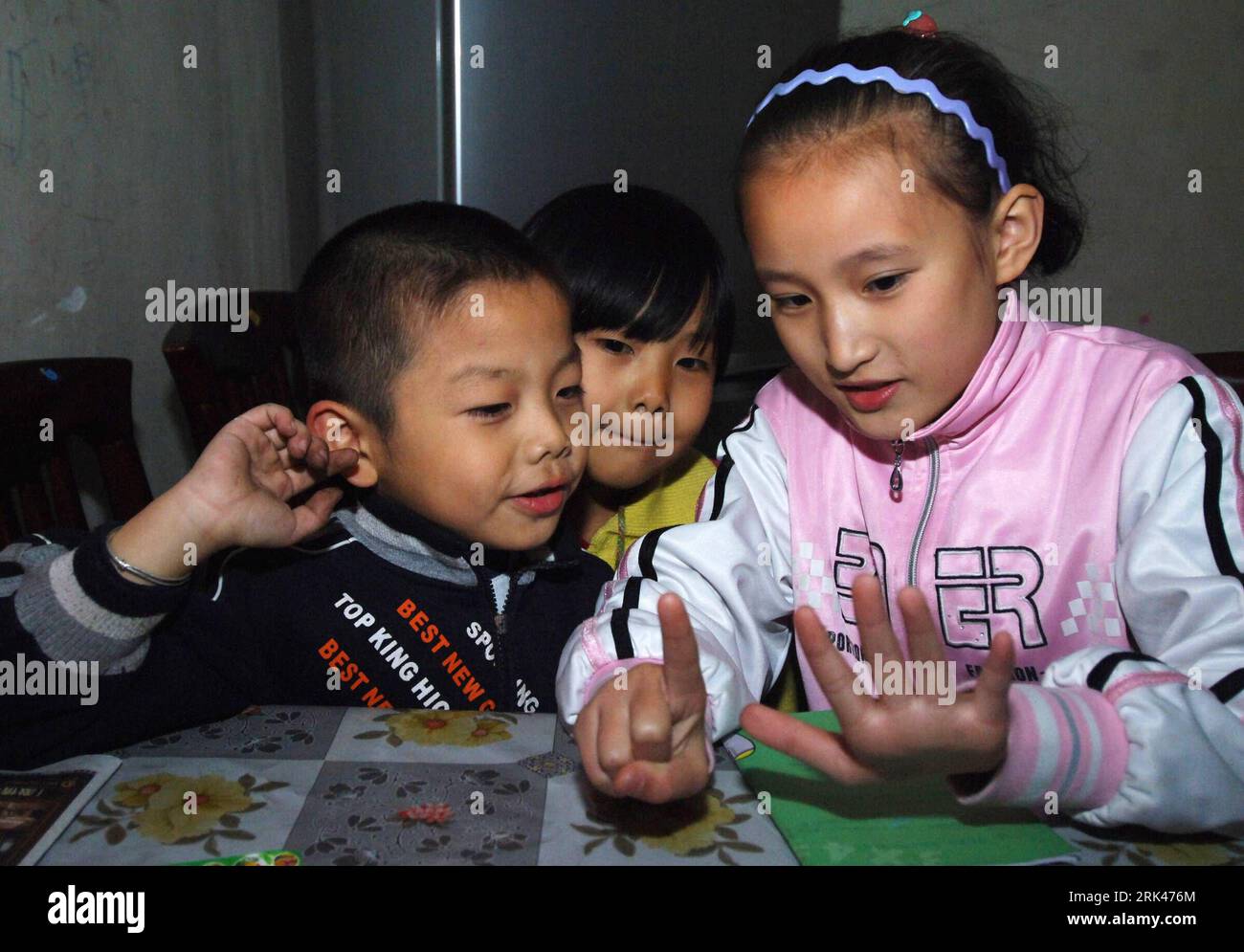 Bildnummer: 53596187  Datum: 31.10.2009  Copyright: imago/Xinhua (091113) -- HEFEI, Nov. 13, 2009 (Xinhua) -- Zhang Ling (R) tutors children of the neighborhood in Hefei, capital of east China s Anhui Province, Oct. 31, 2009. Wang Fang Primary School is located in a corner of Hefei City. As a private school especially for children of migrant workers, it has only ten rented rooms as classrooms, and a small clearing as the playground.  has grown up.  (Xinhua/Li Jian)(zgp) PUBLICATIONxNOTxINxCHN Kinder Land Leute Fotostory kbdig xsk 2009 quer o0 Hausaufgaben, Bruder, helfen    Bildnummer 53596187 Stock Photo
