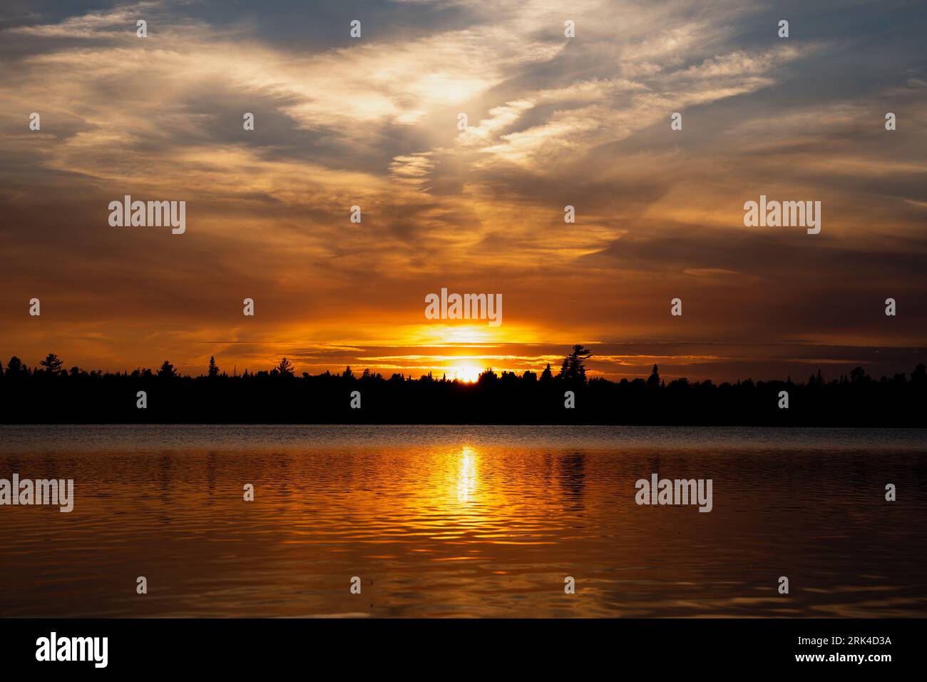 A stunning sunset over the horizon of a tranquil body of water ...