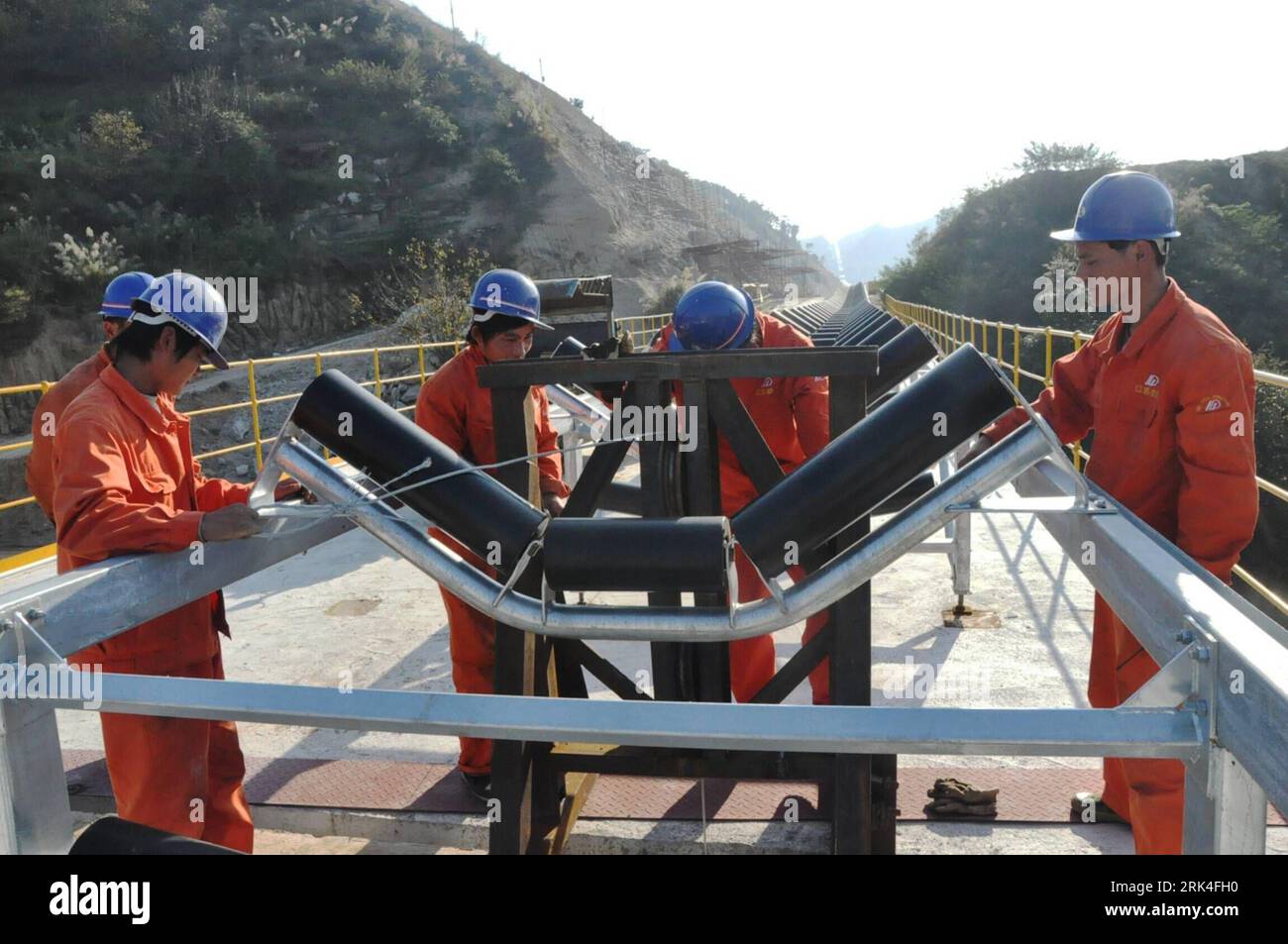 Bildnummer: 53625927  Datum: 23.11.2009  Copyright: imago/Xinhua (091125) -- FENGKAI, Nov. 25, 2009 (Xinhua) -- Workers expedite in the construction with the long distance belt for conveyance of limestone, which boasts a full length of over 40 km and conveyance capability of up to 2,500 tons per hour upon the completion of its construction which adopts the state-of-the-art technology and pipelining, at Fengkai County, south China s Guangdong Province, Nov. 23, 2009. (Xinhua/Wei Shiming) (px) (1)CHINA-GUANGDONG-CONVEYANCE BELT-LIMESTONE-CONSTRUCTION(CN) PUBLICATIONxNOTxINxCHN Wirtschaft Bau Bau Stock Photo