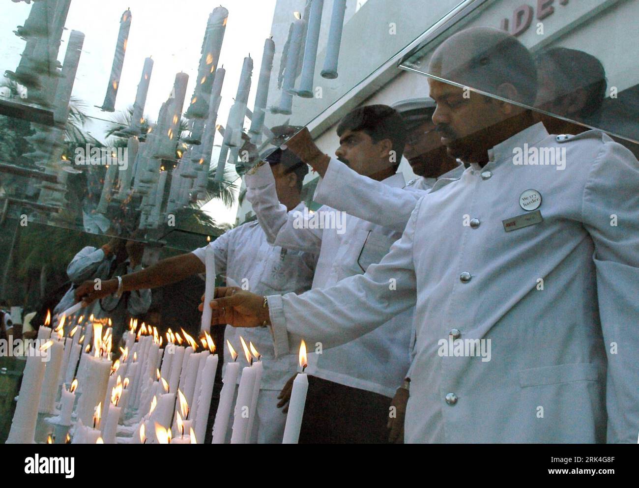 Bildnummer: 53628523  Datum: 26.11.2009  Copyright: imago/Xinhua (091126) -- MUMBAI, Nov. 26, 2009 (Xinhua) -- Staff members of Oberoi Trident hotel light candles to honor victims in front of Oberoi Trident hotel, one of the sites of last year s terror attacks, in Mumbai city of India, Nov. 26, 2009. India marked the first anniversary of the 2008 terrorist attacks on Mumbai on Thursday. (Xinhua) (zcq) (3)INDIA-MUMBAI-VICTIMS-ANNIVERSARY PUBLICATIONxNOTxINxCHN Trauer Gedenken Opfer Mumbai Jahrestag kbdig xcb 2009 quer  o0 Kerze    Bildnummer 53628523 Date 26 11 2009 Copyright Imago XINHUA  Mumb Stock Photo