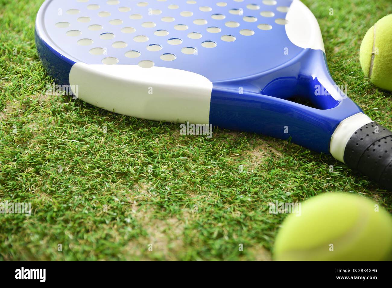 Padel racket and balls on artificial grass floor in outdoor court. Elevated view. Stock Photo