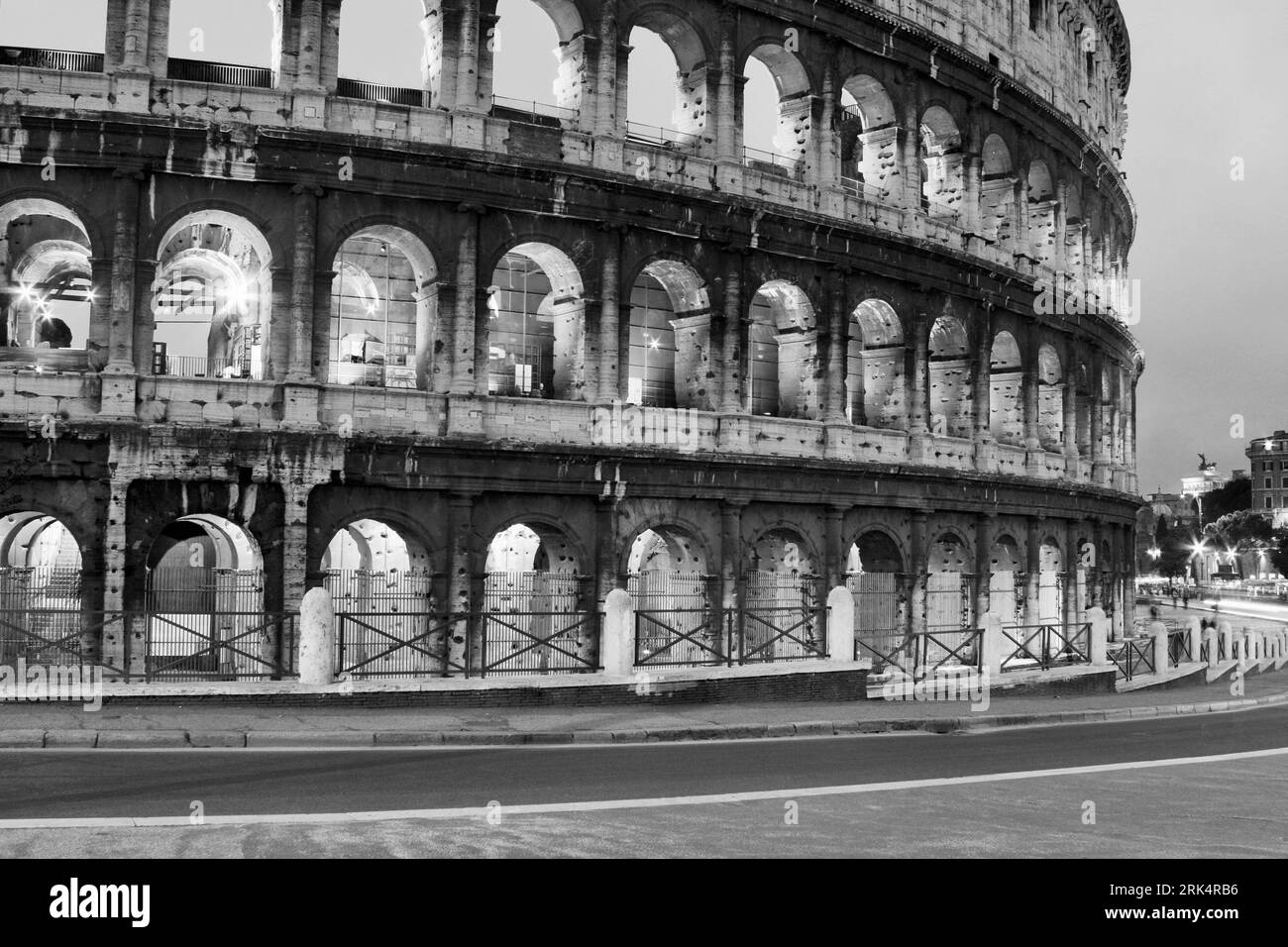 A scenic view of Colosseum illuminated at night in Rome, Italy in grayscale Stock Photo