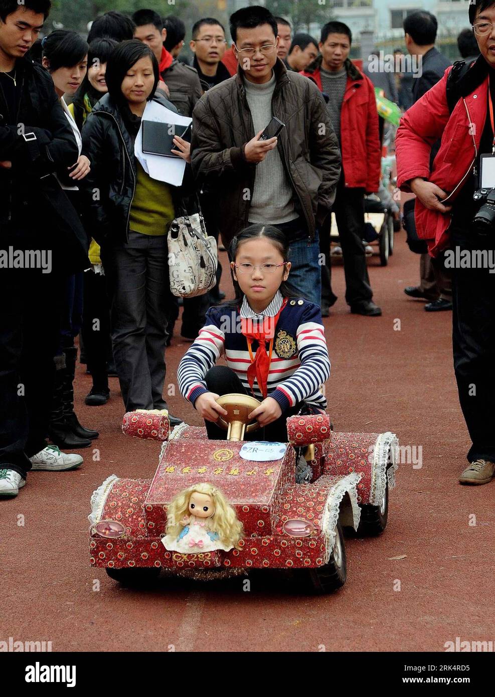 Bildnummer: 53661605  Datum: 11.12.2009  Copyright: imago/Xinhua (091212) -- HANGZHOU, Dec. 12, 2009 (Xinhua) -- Visitors watch a girl pupil driving a car model she designed and made at the final of the Hangzhou creative car models contest held in Hangzhou, east China s Zhejiang province, Dec. 11, 2009. The contest presented more than 30 creative car models made of refuse, whose designers and makers are pupils from schools in the province. (Xinhua/Zhu Yinwei) (wyx) (2)CHINA-ZHEJIANG-HANGZHOU-PUPIL-CREATIVE CAR MODELS (CN) PUBLICATIONxNOTxINxCHN Kinder Auto kurios Verpackung basteln Abfall Recy Stock Photo