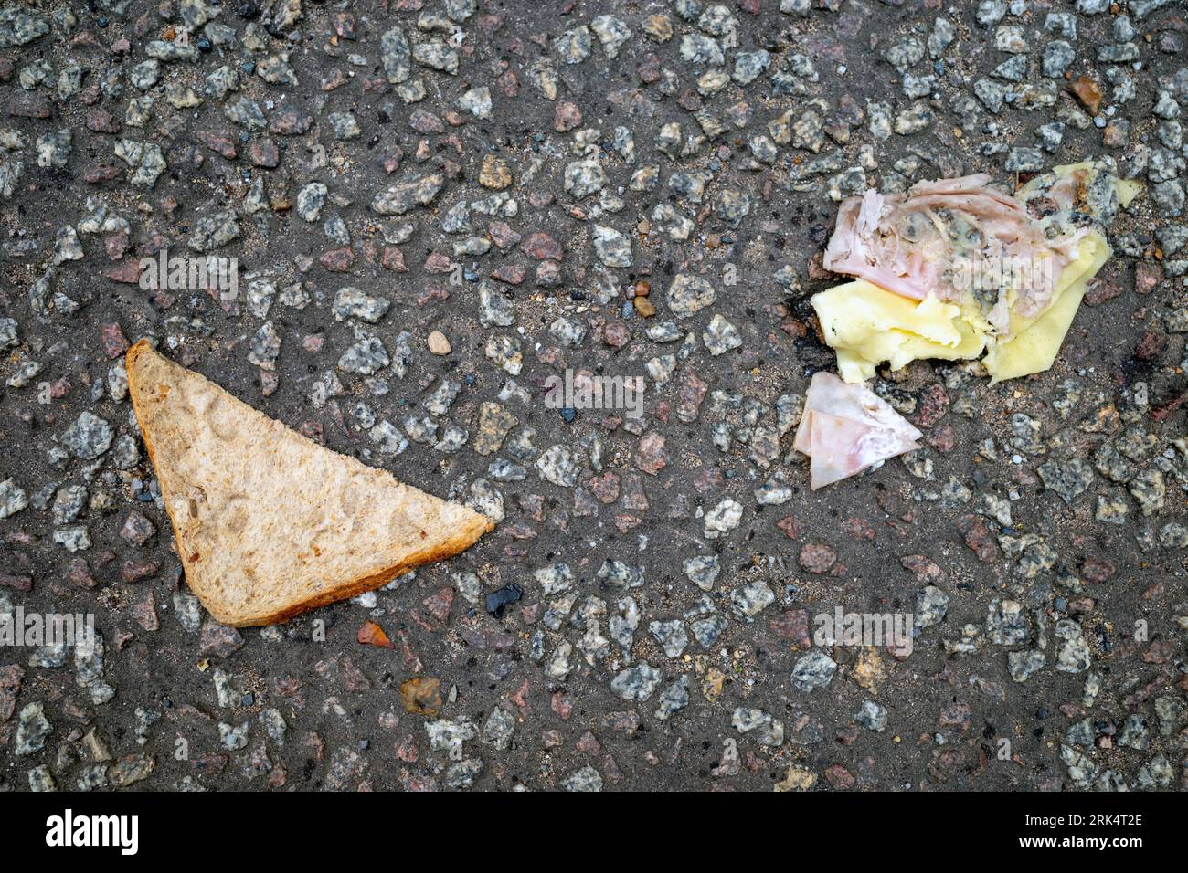 Ham and cheese sandwich fallen onto a road Stock Photo