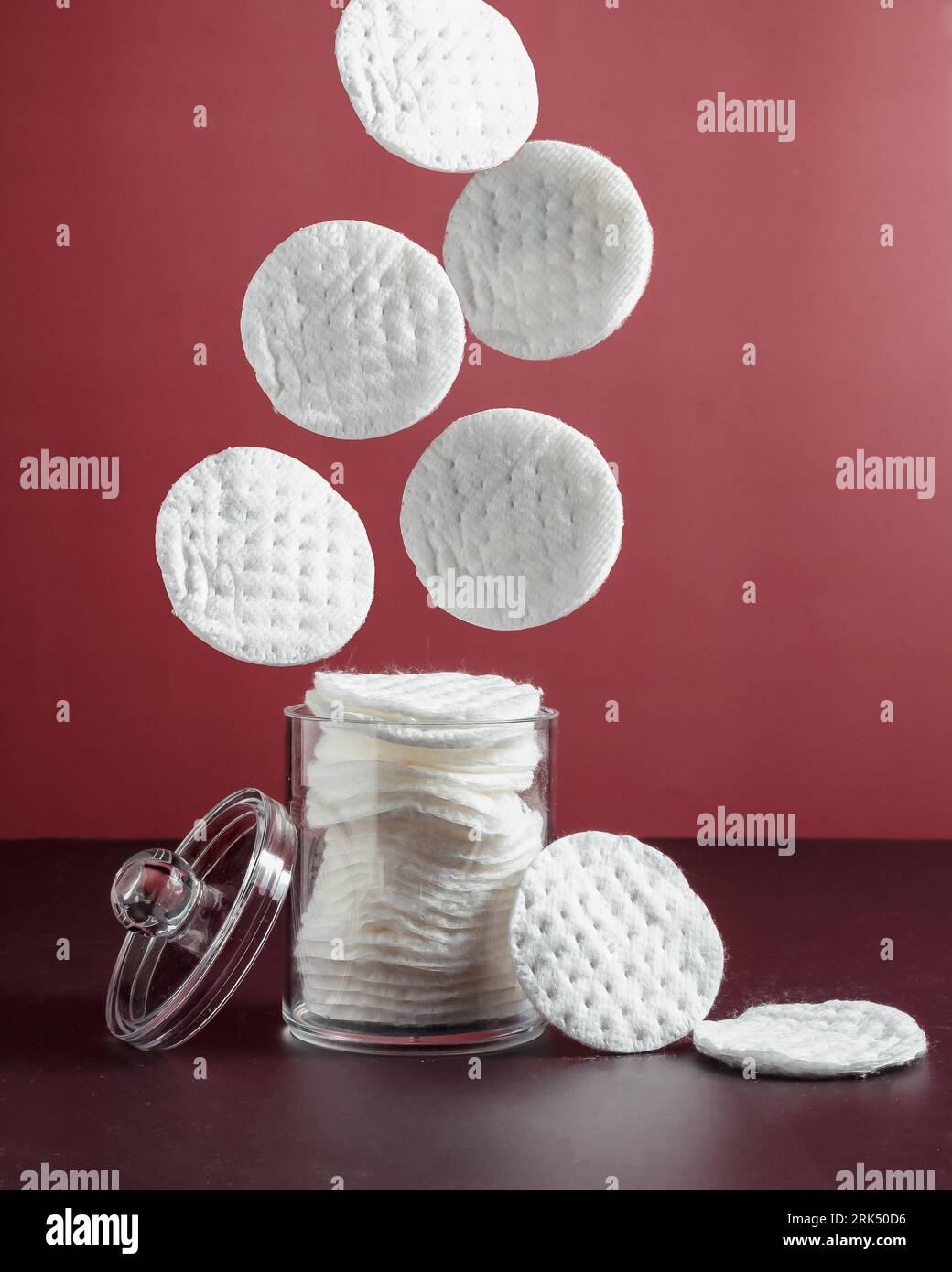 A clear glass jar containing a collection of white, round cotton pads