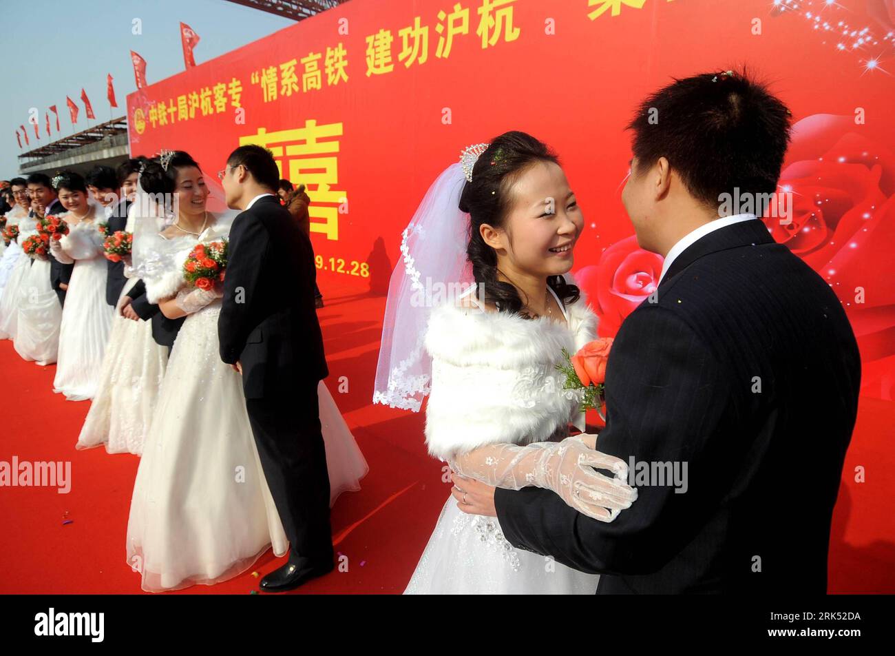 Bildnummer: 53688651  Datum: 28.12.2009  Copyright: imago/Xinhua (091228) -- JIAXING, Dec. 28, 2009 (Xinhua) -- Newly-married couples hug eachother during a group wedding at a building site in Jiaxing, east China s Zhejiang Province, on Dec. 28, 2009. Ten pairs of emplyees of a Shanghai to Hangzhou passenger transport program hold a group wedding on their building site on Monday. (Xinhua/Xu Yu) (lyx) (1)CHINA-ZHEJIANG-BUILDING SITE-GROUP WEDDING (CN) PUBLICATIONxNOTxINxCHN Hochzeit Massenhochzeit kbdig xub 2009 quer     Bildnummer 53688651 Date 28 12 2009 Copyright Imago XINHUA  Jiaxing DEC 28 Stock Photo