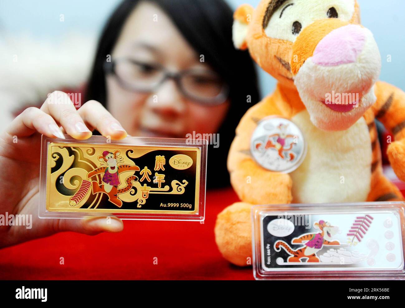 Bildnummer: 53711111  Datum: 07.01.2010  Copyright: imago/Xinhua (100107) -- BEIJING, Jan. 7, 2010 (Xinhua) -- A salesclerk shows gold and silver bars featuring Disney cartoon character Tigger from Winnie the Pooh at a shop in Beijing, capital of China, Jan. 7, 2010. A series of gold and silver Tigger collection were issued recently, to mark the coming Year of Tiger according to the Chinese traditional lunar calendar. (Xinhua) (wqq) (1)CHINA-BEIJING-YEAR OF TIGER-TIGGER FROM WINNIE THE POOH-GOLD AND SILVER COLLECTION (CN) PUBLICATIONxNOTxINxCHN Jahr Tiger Objekte kbdig xcb 2010 quer o0 Teddy K Stock Photo