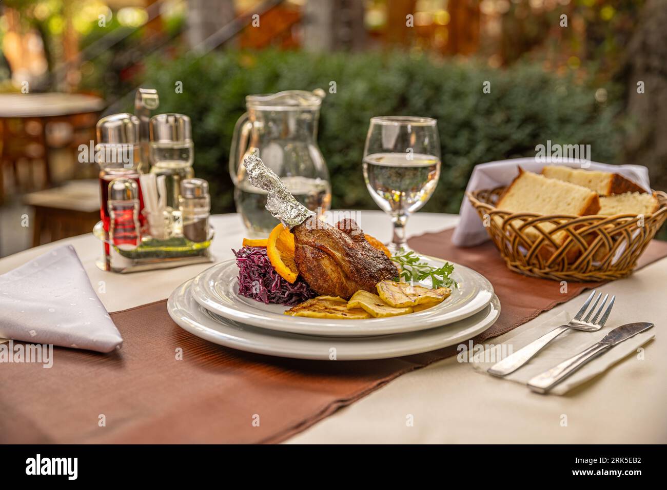 Duck leg confit served with roasted pear and red cabbage Stock Photo