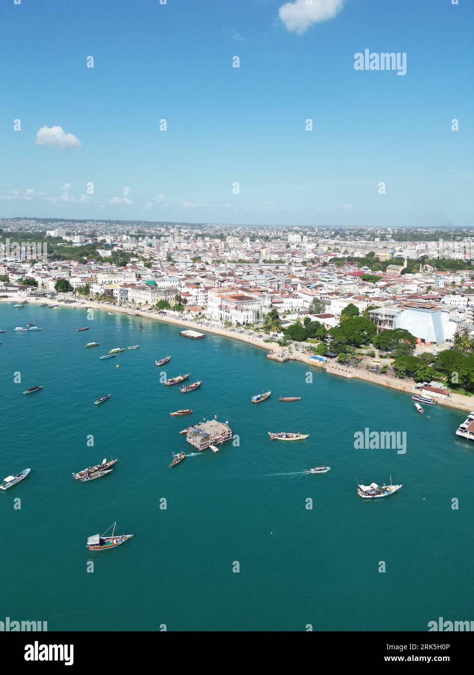 A scenic aerial view of a vibrant city skyline with multiple boats in ...