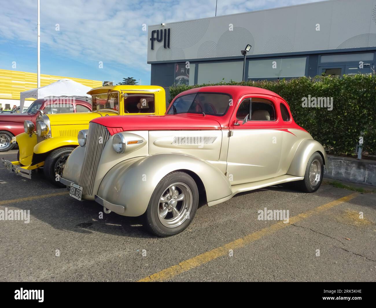 Old colorful 1937 Chevrolet Master coupe street rod in a parking lot at a classic car show. Sunny day Stock Photo