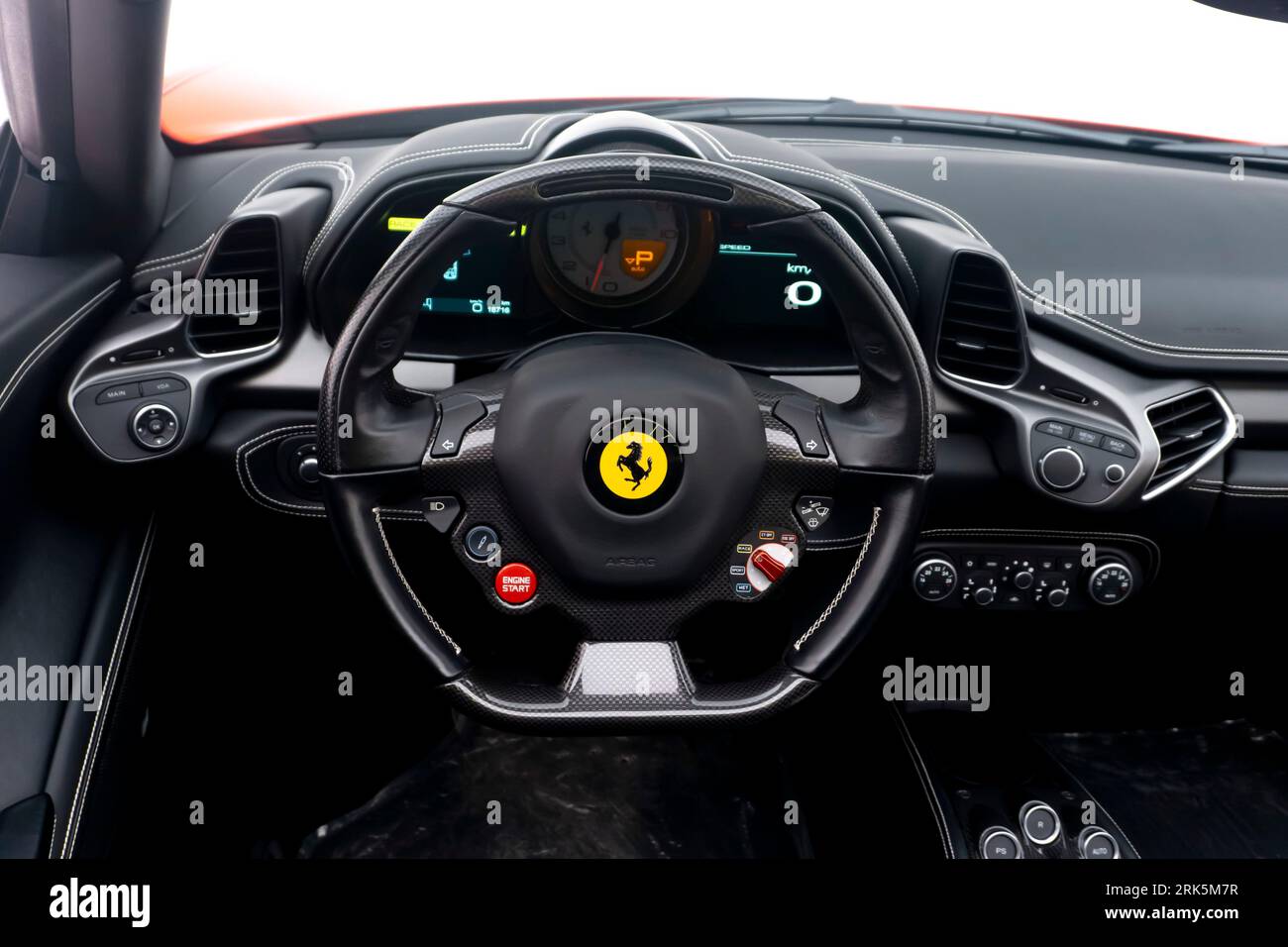 A close-up of a Ferrari steering wheel with its black interior Stock Photo