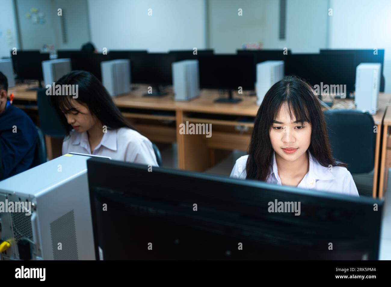 Two East Asian females in a professional office setting using a ...