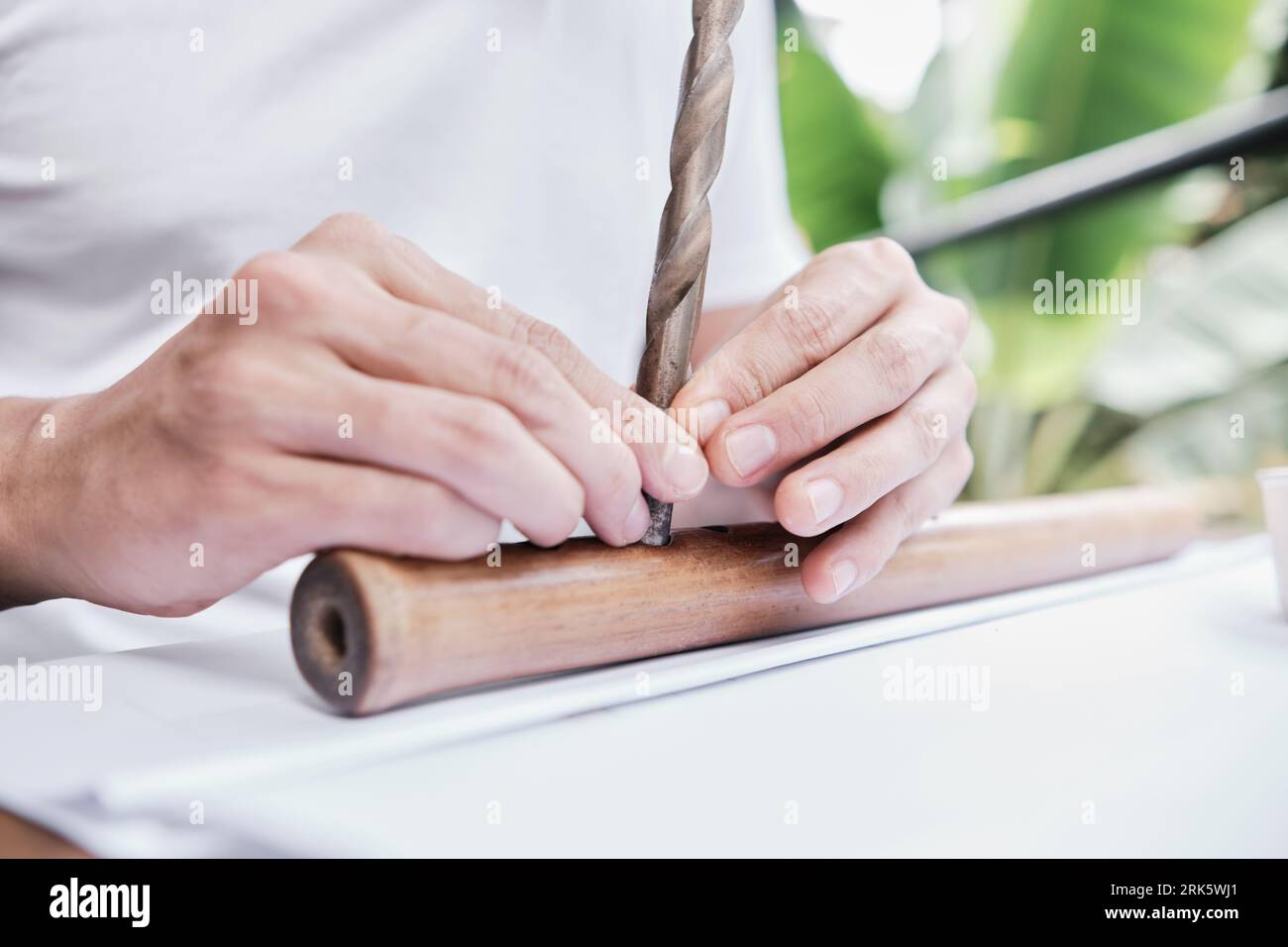 close-up of a young adult male's hands holding a drill bit in a flute Stock Photo