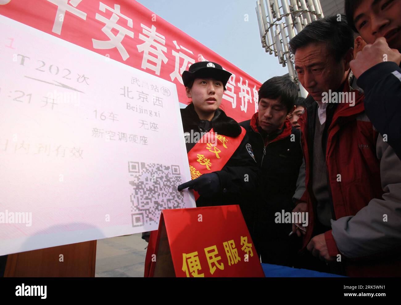 Bildnummer: 53762399  Datum: 28.01.2010  Copyright: imago/Xinhua (100129) -- WUHAN, Jan. 29, 2010 (Xinhua) -- A railway policewoman explains to passengers the knack to identify counterfeit train tickets, during activities on the police camp open day by local railway public security bureau on the theme of escorting and guarding the passengers for a peaceful and safe Spring Festival Transit Peak, on the square of the Wuchang Railway Station, in Wuhan, capital of central China s Hubei Province, Jan. 28, 2010. Policemen from departments of criminal investigation, public order maintenance, sleuth a Stock Photo