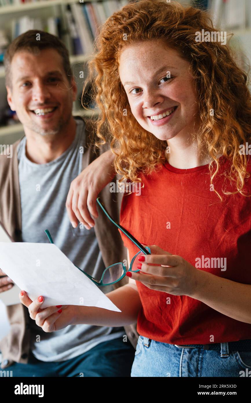 Young manager talking with experienced colleague while using computer in office. Stock Photo