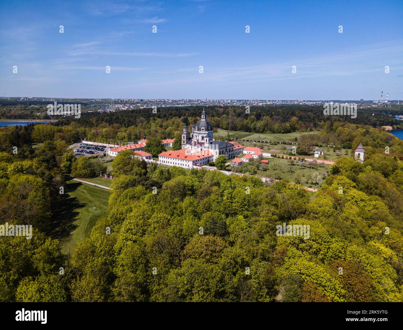 Aerial view of the stunning Pazaislis monastery in Kaunas, Lithuania, featuring a large church, multiple buildings and a lake Stock Photo