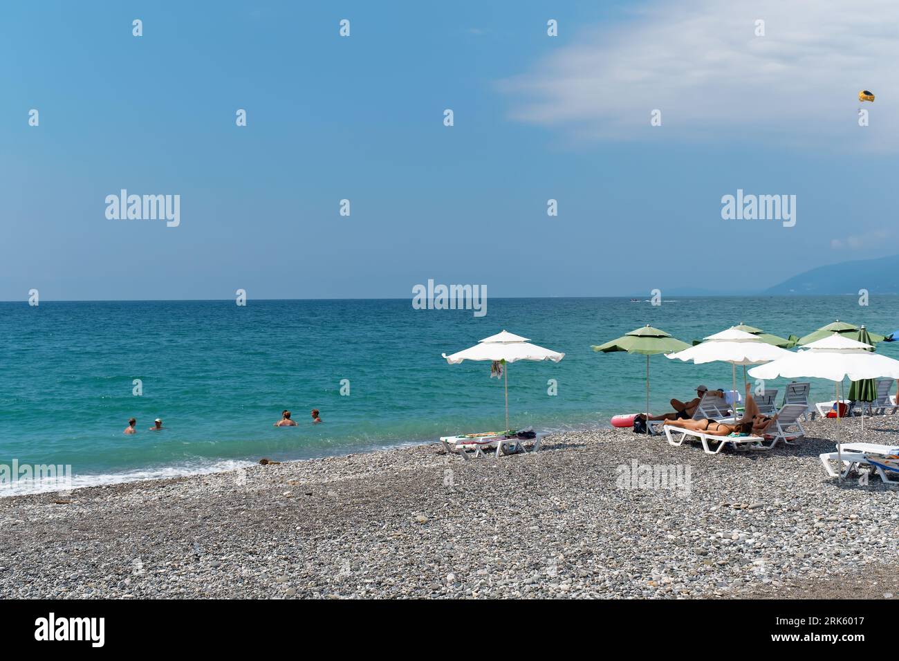The azure sea, the beach, vacationers sunbathing on the shore. Abkhazia ...