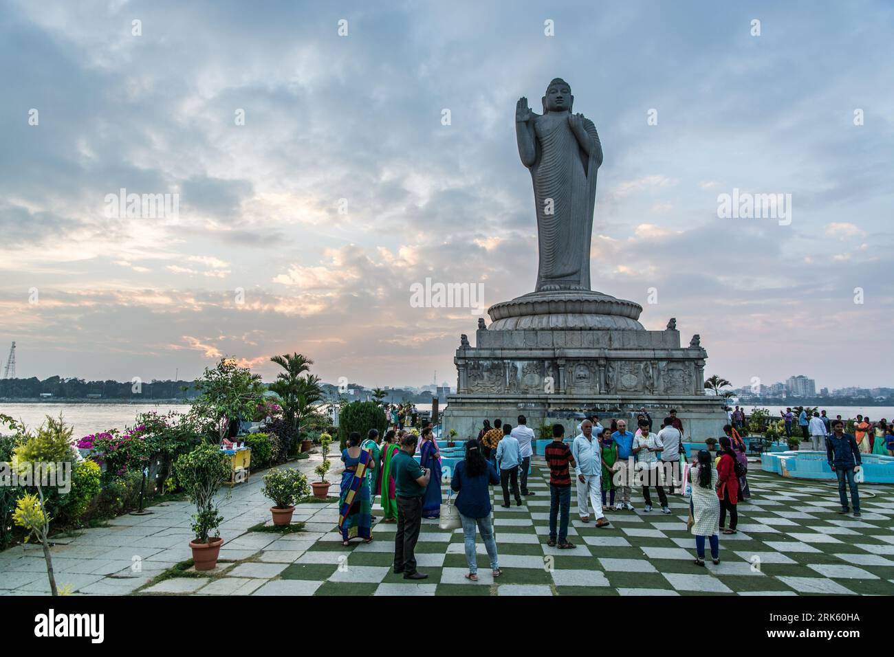 A crowd of people gathered around the Buddha statue on Hussain Sagar