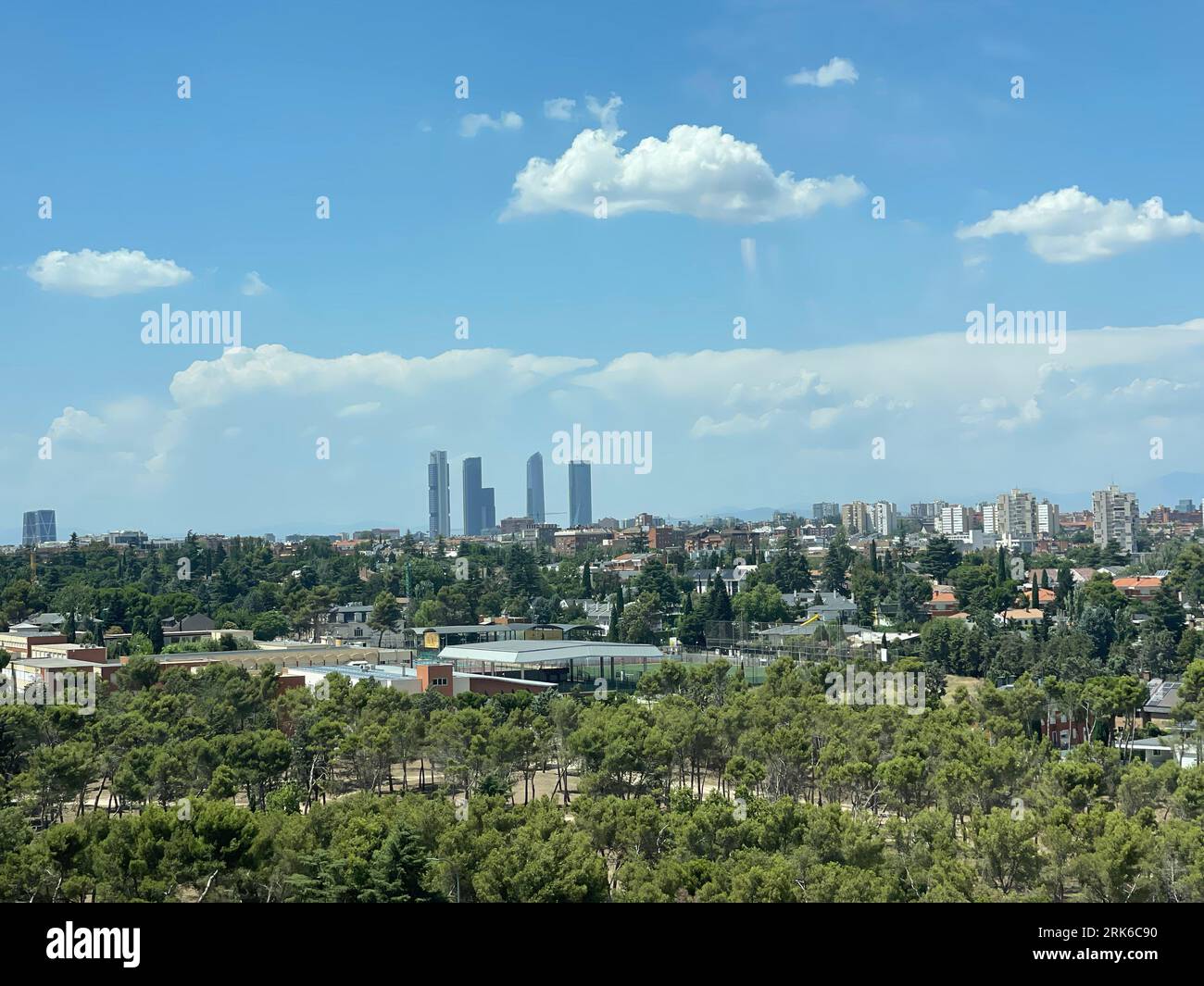An aerial view of a lush green park surrounded by trees, with a city ...